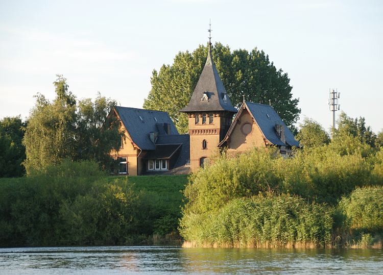 Hamburg Fotograf - Fotos aus den Hamburger Bezirken + Stadtteilen. Grnderzeitvilla, Turm mit spitzem Dach - gelber Ziegelstein.  1509_3774  In der Villa mit dem spitzen Turmdach hinter dem Deich der Norderelbe war das Labor und Teile der Verwaltung der Filtrierwerke von Kaltehofe untergebracht. Weiden und hohes Schilf stehen am Ufer der Elbe.