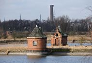 1513_0625  ber Zuflussbrunnen wurde das zu reinigende Wasser in die Filterbecken geleitet. Dort sickerte es durch eine reinigende Sandschicht und floss in kleine gemauerte Abflusskanle von denen aus ber Leitungen zum Pumpwerk Rothenburgsort floss. Blick auf die Brunnenhuser an den Filterbecken auf Kaltehofe - im Hintergrund der Wasserturm der Wasserwerke Rothenburgsort, ber den das Trinkwasser nach Hamburg geleitet wurde.