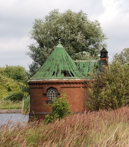 Bilder aus Hamburg Rothenburgsort - Brunnenhaus auf Kaltehofe - beschdigtes Dach.  1517_4640  Die Rnder der Filterbecken auf Kaltehofe sind mit dichtem Schilf bewachsen. Teile des Dachs vom zylindrischen Schieberhuschen sind beschdigt. Ein Drittel der Feinfilteranlage auf Kaltehofe soll ab 2009 erschlossen und der ffentlichkeit zugnglich gemacht werden - ein Industriedenkmal der Wasserzubereitung soll entstehen. Neben einem Caf und einem Wasserkunstmuseum sollen drei der Filterbecken als Biotope erhalten bleiben. Drei weitere Filterbecken werden als Modellbootteich, Planschbecken fr Kinder und Wasserspiele gestaltet.  Die Umnutzung des Gebietes ist umstritten, da u.a. ein Teil der Strasse zu dem Gelnde fr den Autoverkehr geffnet werden soll.