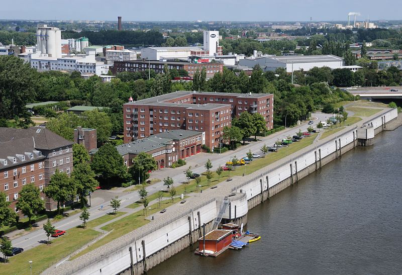 <title>Fotografien aus den Hamburger Bezirken; Hamburg - Mitte, Stadtteil Veddel  Luftbild von der Veddel und dem Gewerbegebiet auf der Peute./ Hamburger Fotograf Christoph Bellin. 213_0007 Blick ber den Mggenburger Zollhafen zum Gewerbe- und Industriegebiet auf der Peute. Am oberen Bildrand lks. der Wasserturm von Hamburg Rotenburgsort und rechts die rauchenden Schlote der Mllverwertungsanlage Borsigstrasse. Im Vordergrund zwischen den beiden Wohngebuden die Feuerwache Veddel - das Gebude ist vom ehe. Oberbaudirektor Fritz Schumacher entworfen.