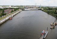 215_0056 Blick ber den Mggenbrger Zollhafen zur Autobahnbrcke der A255; dahinter sind die hohen Industrieschornsteine der Aurubis, vorm. Norddeutsche Affinerie auf der Peute zu erkennen. Im Vordergrund hat gerade eine Barkasse der roten Maritimen Circle-Line am Anleger Ballinstadt fest gemacht. Links hinter der Sturmflutmauer das flache Gebude der Feuerwehr Veddel.