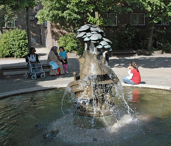 222_0457 Die Bronzeskulptur des wasserspeienden Brunnens an der Slomanstrasse auf der Veddel hat dei Knstlerin Doris Waschk-Balz 1982 entworfen. Einwohnerinnen der Veddel sitzen bei der Brunnenanlage und geniessen die Ruhe. Bilder aus dem Bezirk Hamburg-Mitte; Stadtteil Veddel Wasserbrunnen an der Slomanstrasse - Hamburgfotos Christoph Bellin. 