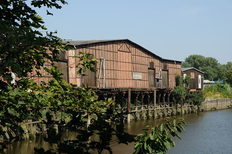 Hamburg-Fotos aus dem Bezirk Hamburg-Mitte, Stadtteil Veddel. historisches Fachwerk-Lagerhaus am Veddeler Marktkanal. Hamburgfotografie Christoph Bellin. 227_4326 Blick ber den Veddeler Marktkanal zu einem historischen Lagerhaus am Ufer des Kanals. Ein Steg und Eisendalben ermglichten ein Anlegen von Schiffen. Das Lagergebude ist in Fachwerkbauweise errichtet, die Zwischenrume sind mit Zeigelsteinen ausgefllt. Der hintere Teil des Marktkanal hat keinen Zufluss zu Elbe mehr