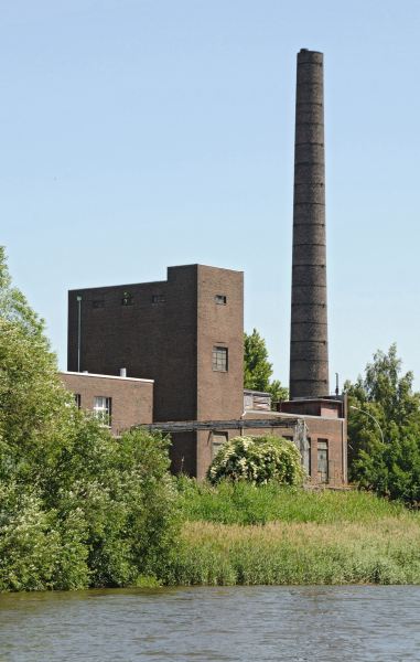 Bilder von der Peute Hamburg Veddel. Industriegebude mit Fabrikschornstein. Fotos aus Hamburg - Fotograf Christoph Bellin. 234_9505 Altes Fabrikgebude mit hohem Ziegelschornstein am Ufer des Hovekanals. Das Ufer des Veddeler Wasserwegs ist dicht mit Schilf und Struchern bewachsen.