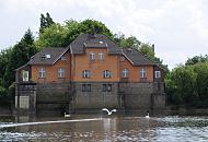 236_8446 Schleusengebude der Mggenburger Schleuse; die Schleuse, die am Ende des Mggenburger Kanals und des Hovekanals lag, verband die Veddeler Wasserwege mit der Norderelbe. Schwne schwimmen auf dem Kanalgewsser, einer der grossen Schwimmvgel hebt gerade ab.