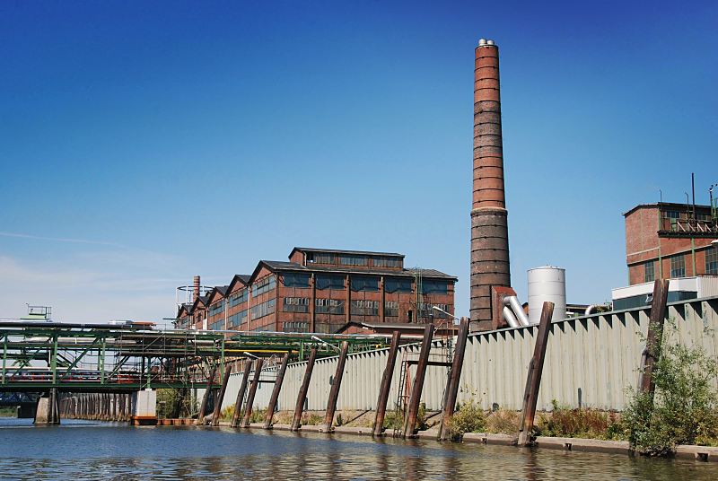 Fotos aus den Hamburger Stadtteilen: Peute / Veddel, Bezirk Hamburg-Mitte Mggenburger Kanal - historische Fabrikgebude und Fabrikschornstein.Hamburg-Fotos Christoph Bellin.239_4011 Blick ber den Mggenburger Kanal zum Betriebsgelnde der Aurubis, die als Norddeutschen Affinerie ihren Betrieb 1913 auf die Peute verlegt hat. Historische Fabrikanlagen zeugen von der Geschichte des Industriegebiets.