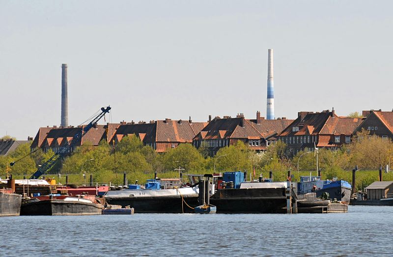 Bilder aus dem Bezirk Hamburg Mitte - Stadtteil Veddel. Blick ber den Spreehafen zur Wohnbebauung an der Harburger Chaussee. Hamburgfotos von der Veddel. 243_6869 Binnenschiffe und Arbeitskhne liegen am Spandauer Ufer des Spreehafens, rechts ist ein Hausboot am gegenber liegenden Berliner Ufer zu erkennen. Im Hintergrund Wohnblocks an der Harburger Chaussee.