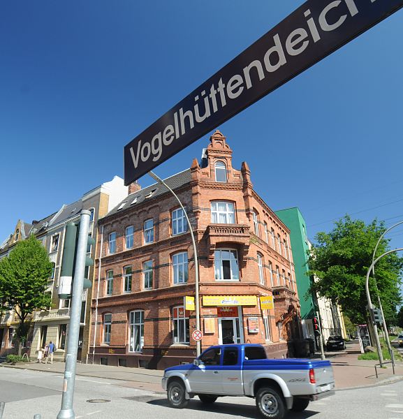 Grnderzeit-Architektur am Wilhelmsburger Vogelhttendeich  Fotos aus den Bezirken Hamburgs; Stadtteil Wilhelmsburg  100_9223 Backstein-Wohnhaus im Stil der Grnderzeit am Wilhelmsburger Vogelhttendeich. Hamburger Strassenschild mit Strassennamen in weisser Schrift auf blauem Grund. www.bilder- hamburg.de