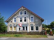 109_8944 Grnderzeit-Gebude am Niedergeorgswerder Deich - die Fassade des Bauernhauses ist mit gelbem Klinker verkleidet und die Fenster sind mit weissen Stuckdekoren und Sulen versehen. Im Hintergrund ein Windrad der Windkraftanlage Georgswerder. www.bilder-hamburg.de