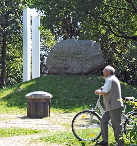 Fotos Hamburger Bezirke / Mitte; Wilhelmsburg,  Kirchdorf Deichdenkmal + Flutopfer Mahnmal  115_8989 Das Deichdenkmal erinnert an die 1333 begonnene Eindeichung Wilhelmsburg; es wurde 1933 errichtet, die Daten sind in eine grossen Findling graviert. Als Mahnmal wurden 1964 die weissen Stelen aufgestellt, die an die Opfer der Flutkatastrophe von 1962 erinnern sollen. Damals kamen ca. 200 Menschen aus Wilhelmsburg ums Leben. www.fotos- hamburg.de