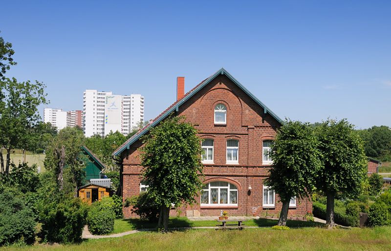 Bilder aus dem Hamburger Stadtteil Wilhelmsburg,  Stillhorn Bauernhaus - Hochhaussiedlung Kirchdorf Sd 132_1_1027 Altes Bauernhaus im Hamburg-Stillhorn am Deich zur Sderelbe - Linden stehen vor dem Ziegelgebude. Im Hintergrund Hochhuser der Siedlung Kirchdorf-Sd.