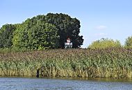 137_9802 An der Bunthuser Spitze der Wilhelmsburger Elbinsel teilt sich die Elbe in die Norderelbe und Sderelbe. Das Leuchtfeuer Bunthaus hat die Schifffahrt ab 1914 bis 1977 mit einem Rundumfeuer auf die Fahrwassertrennung hingewiesen. Der Leuchtturm aus Holz hat eine Hhe von ca. 7m; die historische Leuchtfeueranlage ist als letztes Leuchtfeuer dieser Bauweise seit 2005 unter Denkmalschutz. Hohes Schilf steht am Ufer der Sderelbe. 