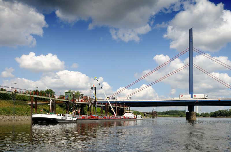 Fotos aus den Hamburger Bezirken - Mitte; Wilhelmsburg - Georgswerder, Norderelbe Tankschiff am Anleger Georgswerder  - Autobahnbrcke ber die Norderelbe. 143_0594 An der Anlegestelle Georgswerder liegt ein Tankschiff und wird ber ein Schlauchsystem entladen. Autobahnbrcke mit Polygon und Seilen; auf der A1 ber die Norderelbe fahren Lastwagen; im Hintergrund die Schornsteine vom Kraftwerk Tiefstack.