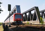 155_0971  Seit 1872 berquerte die Bahn die Sderelbe ber eine Bogenbrcke; diese wurde 1970 abgerissen und durch dei 340m lange Fachwerkbrcke ersetzt. Ein roter Zug der Hamburger S-Bahn kommt aus Harburg und fhrt Richtung Hamburg Altona.