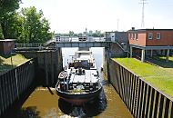 160_0930  Ein Binnenschiff hat seine Fracht im Hamburger Hafen gelscht und fhrt ohne Ladung durch das geffnete Schleusentor der Reiherstiegschleuse in die Sderelbe. Rechts das ehem. Schleusenwrterhaus; die Schlickschleuse am Reiherstieg wird ferngesteuert - ein Radar erfasst die ankommenden Schiffe. Auf der gegenberliegenden Seite der Sderelbe sind die ehem. Silobauten und Fabrikgebude des Harburger Hafens zu erkennen.