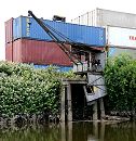 172_0807 Containerlager mit leeren Containern am Ufer des Schmidtkanals. Ein alter, verrotteter Hafenkran zeugt davon, dass dort ursprünglich Güter von Schuten gelöscht und an Land gehievt wurden.  
