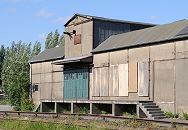 178_0239 Ein stillgelegtes Lagergebude einer Hamburger Spedition mit Gleisanschluss - die Gleise sind mit Wildkraut berwuchert, die Fenster hinter der Laderampe sind vernagelt.