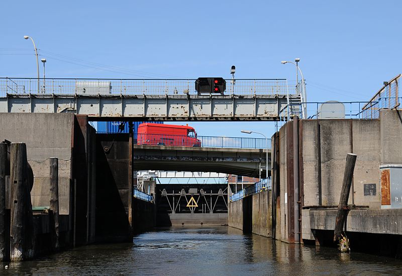 Ernst-August-Schleuse, Schleusenkammer - Holzdalben, Schleuseneinfahrt  53_8632 Blick in die Schleusenkammer der Ernst-August-Schleuse vom Ernst-August-Kanal; das Schleusentor ist geffnet, auf der gegenberliegenden Seite die Ausfahrt in den Reiherstieg. Ein Transporter passiert die Brcke ber die Schleusenanlage - das Signallicht ber der Schleuseneinfahrt zeigt, das keine Einfahrt gestattet ist.  www.fotograf-hamburg.com