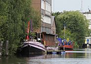 75_7357 Auf dem Veringkanal liegen bunte Hausboote - die Uferzone ist dicht mit Weiden und Erlen bewachsen; im Hintergrund ist die Spitze des Hamburger Fernsehturms zu erkennen. Der fast 2 km lange Wilhelmsburger Veringkanal ist 1896 angelegt worden - die an seinen Ufern angesiedelten Industriebetriebe nutzten den Wasserweg zum Transport der Gter per Schute zum Reiherstieg oder zur Elbe.  www.fotograf- hamburg.de