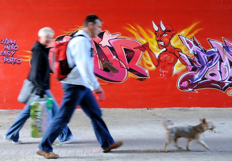 Fussgngertunnel unter der Wilhelmsburger Reichsstrasse, Graffiti  Hamburgfotos aus dem Bezirk Hamburg-Mitte,  Stadtteil Wilhelmsburg  92_9719 Fussgnger mit Hund unterqueren die Wilhelmsburger Reichsstrasse im Fugngertunnel - an der Mauer ist ein Graffiti mit Teufel angesprht.  www.fotos-hamburg.de