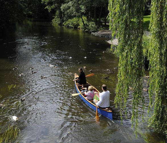 Bild von der Bille bei Bergdorf -  Foto aus dem Stadtteil Bergedorf   11_21554 Tief hngen die Zweige der Weide ber das Wasser der Bille in der Hhe vom Gewerkschaftsweg im Hamburger Stadtteil Bergedorf. Ein Kanu hat gerade auf seiner Tour mit seinen Fahrern die Brcke passiert und flussabwrts. Enten schwimmen auf dem Wasser und warten darauf gefttert zu werden. www.hamburg-fotograf.com