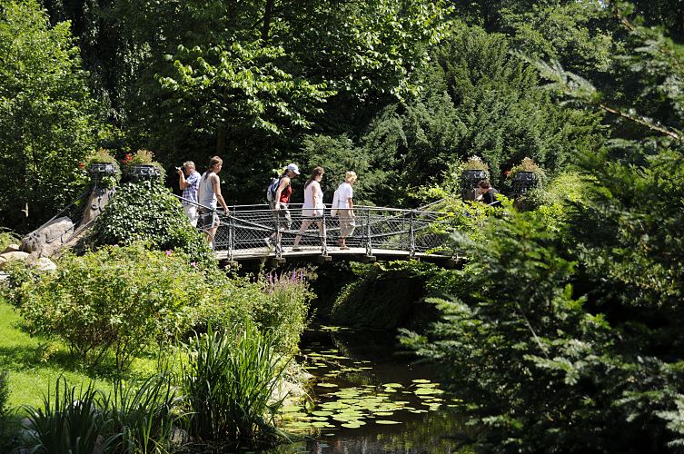 Bergedorfer Schloss - Brcke ber den Schlossgraben - Touristen im Schlosspark   11_21556 Der Wassergraben vom Bergedorfer Schloss wird mit dem Wasser der Bille gespeist. Bergedorf Besucher gehen ber die historische Brcke ber den Schlossgraben in den Schlosspark. Ein Fotograf fotografiert die eisernen Blumenkbel die an den Brckenenden als Dekoration stehen. www.hamburg-fotograf.com