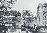 11_21559 Blick ber die aufgestaute Bille - ein Schiffer sitzt in seinem Kahn, dahinter ein Fischerboot mit Reusen an Bord. Am Teichufer am Bergedorfer Markt, Alte Holstenstrasse liegen weitere Schiffe. Rechts ein mehrstckiges Backsteingebude der Grnderzeit in der die Bergedorfer Bank ihren Sitz hatte (?).  www.hamburger-fotoarchiv.de