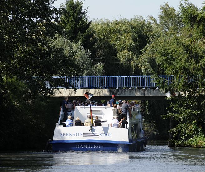 Hamburger Bilder - Fahrgastschiff mit Bergedorf Touristen bei Curslack.   11_21587 Das Bergedorfer Touristenschiff SERRAHN STAR hat auf seiner Vierlanden Tour vor dem Neuengammer Stichanal gewendet und passiert gerade die BLAUE BRCKE in Hamburg Curslack, Bezirk Bergedorf. Die Schiffe der Bergedorfer Schifffahrtslinie, die u.a. die Vierlnder Touren anbieten sind sehr flach gebaut, damit sie in der Lage sind, die niedrigen Brcken auf der Strecke zu passieren.  www.hamburg-fotos.org 