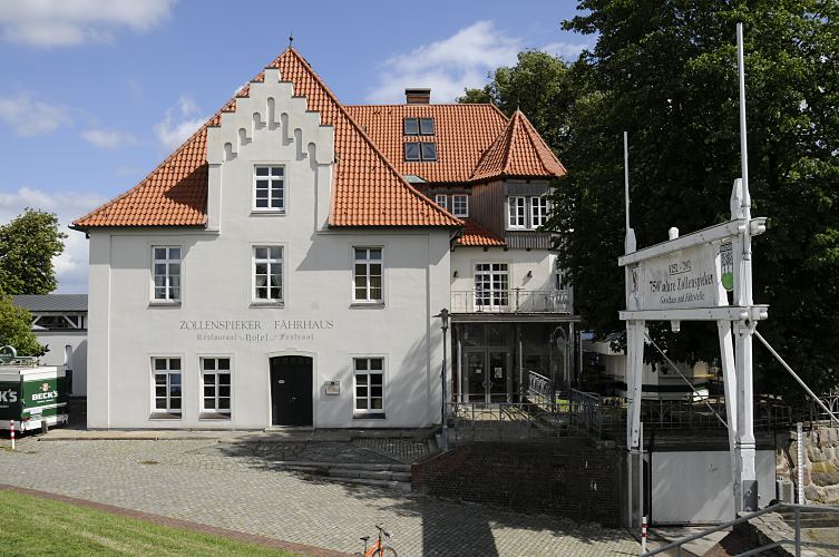 Hamburg Architektur Fotografie - Gebude des Zollenspieker Fhrhaus, Kirchwerder  11_21621 Architektur des historischen Zollenspieker Fhrhaus - der Zollenspieker wurde erstmals Mitte des 13. Jhd. als Zollstation erwhnt. Das Gebudes des Zoll- und Fhrhaus wurde ursprnglich ca. 1460 errichtet - eine wehrhafte Neuanlage wurde dann um 1620 gebaut. Die Wartezeit auf die Fhre nach Hoopte konnte in dem angegliederten Gaststtte verkrzt werden. Ende des 19. Jhd. entwickelte sich das Zollenspieker Fhrhaus zum beliebten Ausflugsziel fr die Hamburger Bevlkerung. Rechts ber den Torpfosten ein Hinweisschild, dass der Zollenspieker schon mehr als 750 Jahre als Gasthaus und Fhrstelle existiert.  www.bilder-hamburg.de