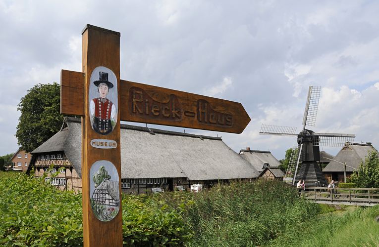 Bild vom geschnitzten Holzschild Freilichtmuseum Rieck-Haus, Bauernhaus - Windmhle  11_21633 Das handgeschnitzte Holzschild weist fr die Besucher den Weg zum Rieck Haus, dem Freilichtmuseum in den Hamburger Vierlanden; die Anlage ist seit 1954 eine Aussenstelle des Altonaer Museums. Das Rieckhaus in Hamburg Curslack wurde ca. 1550 errichtet und ist ein typisches niederdeutsches Fachhallenhaus - es soll zu den ltesten Profanbauten Hamburgs gehren.  www.hamburg-bilder.org