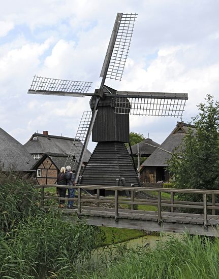 Fotografie Windmhle - Bilder Feldentwsserung Vierlande  11_21636  Feldentwsserungsmhle am Entwsserungsgraben im Freilichtmuseum Rieck-Haus. Eine Holzbrcke fhrt ber den Graben, Schilf und Gras wachsen am Ufer. Die Windmhle stand frher in Ochsenwerder und wurde 1952 zum Freilichtmuseum Curslack gebracht. www.hamburg-bilder.org