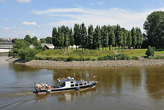 01127_3913 JEin Sportboot / Motorboot kommt vom Oberhafenkanal und fhrt in die Norderelbe ein - im Hintergrund der Elbpark Entenwerder mit den in einer Rundung 2007 bei der Gestaltung der Grnanlage neu angegepflanzten Pappeln. Das Ufer ist mit Steinen gegen die Strmung gesichert; lks. die Einfahrt zum Haken.