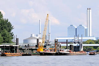 01136_6713 Arbeitsschiffe am Anleger Entenwerder, Hamburg Rothenburgsort / Norderelbe; am Ponton haben ein Schwimmkran lund mehrere Schuten festgemacht. Dahinter die Tore vom Sperrwerk Billwerder Bucht und die hohen Gebude und Schornsteine vom Heizkraftwerk Tiefstack. 