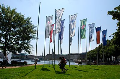 011_15922 - Rasenflche Lombardsbrcke / Neuer Jungfernstieg; Fahnenmasten mit Flaggen im Wind - Spaziergnger in der Sonne.