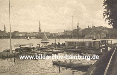 011_15926 - Blick vom Ufer Neuer Jungfernstieg Richtung Jungfernstieg - im Vordergrund befindet sich ein Bootsverleih, bei dem Ruderboote, Kanus und Segelboote geliehen werden knnen. Ganz links im Hintergrund der Turm der St. Jacobikirche und rechts davon die St. Petrikirche.