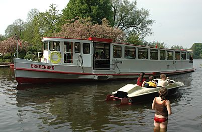 011_14052 - die Bredenbek verlsst den Stadtparksee; vorbei an einem Tretboot und dem erste Badegast der Saison.