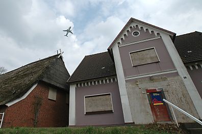 04_23189 die Fenster und Tren der Gebude sind vernagelt; der Abriss ist offensichtlich geplant; im Himmel startet ein Airbus A 380.