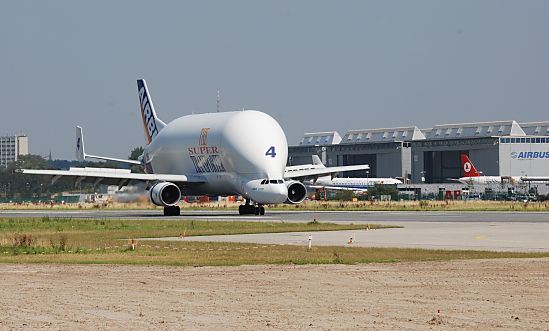 011_15903 die Beluga rollt auf der Landebahn aus. Im Hintergrund Flugzeughallen der Airbuswerke.