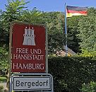 11_21460 Hamburgs sdstliche Stadtgrenze; ein rotes Schild mit weisser Schrift "Freie und Hansestadt Hamburg" weist auf die Grenze zum Stadtstaat Hamburg hin. Die Burg mit den Trmen und Zinnen ist das Wappen Hamburgs. Das weisse Schild darunter zeigt den Beginn des Hamburger Bezirks Bergedorf.  www.hamburg-fotograf.com