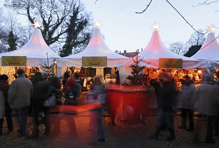 Foto von Marktstnden auf dem Bergedorfer Weinachtmarkt am Schloss   11_21476 Die Besucher und Besucherinnen schlendern am frhen Abend ber den Bergedorfer Weihnachtsmarkt. Die Marktstnde sind festlich beleuchtet und mit Tannenbumen und beleuchteten Sternen geschmckt. www.hamburg-fotograf.com