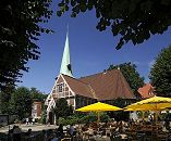 11_21478 Schon um 1162 wurde ein Kirchengebude am jetzigen Ort der Kirche im Zentrum des Stadtteils Bergedorf erwhnt. Die ursprngliche Kirche St. Petri und Pauli wurde 1502 eingeweiht und 1759 der jetzige Kirchturm errichtet. Rechts im Hintergrund das Pfarrhaus und links der Klinkerturm vom Hasse-Haus. Gste sitzen unter Sonnenschirmen im Caf auf dem Kirchplatz und geniessen das Sommerwetter mit strahlend blauem Himmel. www.hamburg-fotograf.com