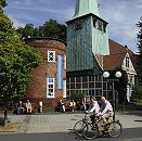 11_21484 Blick ber den Kirchenplatz zum Turm des Hasse - Hauses und der Bergedorfer Kirche St. Petri und Pauli Kirche. Bergedorfer sitzen auf Holzbnken  in der Sonne vor dem historischen Gebude - Ensemble; Fahrradfahrer fahren auf der verkehrsberuhigten Strasse. In dem Fachwerkgebude, dem frheren Organistenhaus, wurde 1699 der Rokoko Komponist Johann Adolph Hasse geboren. Der runde Klinkerturm ist erst 1836 errichtet - dort ist jetzt das Bergedorfer Touristenbro, die Bergedorf - Info eingerichtet.  www.hamburg-fotograf.com