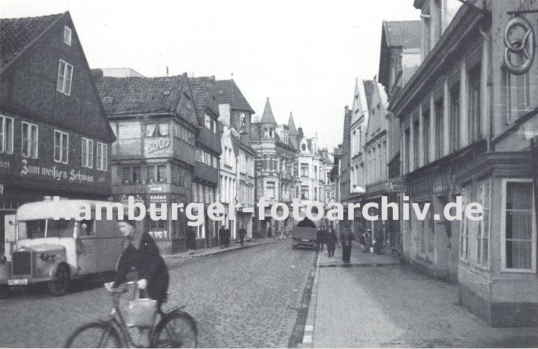 11_21494 Die damalige Sachsenstrasse ca. 1936 ist mit Kopfsteinpflaster befestigt. Ein Lastwagen steht vor der Gaststtte Zum weissen Schwan. Eine Fahrradfahrerin berquert die Strasse - an dem Lenker des Fahrrads hngt eine Einkaufstasche.  www.hamburger-fotoarchiv.de  Fotos vom alten Hamburg Bergedorf - alte Bilder aus den Stadtteilen der Hansestadt