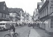 11_21494 Die damalige Sachsenstrasse ca. 1936 ist mit Kopfsteinpflaster befestigt. Ein Lastwagen steht vor der Gaststtte Zum weissen Schwan. Eine Fahrradfahrerin berquert die Strasse - an dem Lenker des Fahrrads hngt eine Einkaufstasche.  www.hamburger-fotoarchiv.de