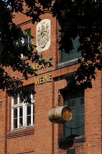 Fotografie Speichergebude, Weinfass    11_21530 Historisches Speichergebude der Weinhandlung von Have. ber der Inschrift ist ein Wappen eingelassen; vor einer der Speichertren hngt an Seil und Haken einer Dachwinde ein Weinfass als Dekoration.  www.hamburg-fotograf.com