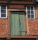 11_21531 Historisches Fachwerkgebude in der Bergedorfer Einkaufsstrasse Sachsentor. Das Fachwerk- haus wurde 1700 errichtet; die Farbe blttert von der Speichertr ab, die von zwei alten Trscharnieren / Langbndern gehalten wird.  www.hamburg-fotograf.com