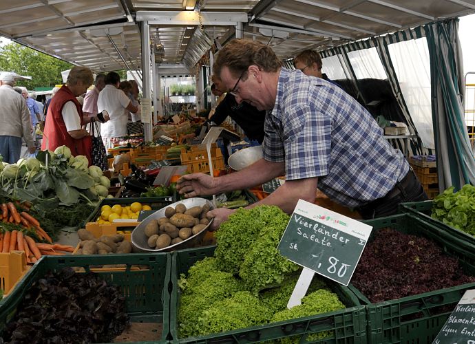 Bilder aus Hamburg Bergedorf - Fotos vom Marktstand mit frischem Gemse aus Vierlanden   11_21544 Marktstand mit frischem Gemse auf dem Bergedorfer Wochenmarkt - der Markthndler fllt gerade Vierlnder Kartoffeln in eine Waagschale. Im Vordergrund stehen Gemsekisten gefllt mit den unterschiedlichsten Sorten Vierlnder Salate. Die Vierlande gehren zum Bezirk Bergedorf und bestehen aus den Orten Kirchwerder, Neuengamme, Altengamme und Curslack - die Gegend wird auch als der Gemsegarten / Blumengarten Hamburgs bezeichnet - die Bauern verkaufen ihre Erzeugnisse hufig auch direkt u.a. auf dem Bergedorfer Wochenmarkt. www.hamburg-fotograf.com