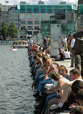 011_151783 - Blick ber den Alster- anleger am Jungfernstieg zur neuen Fassade der Europa Passage; Menschen sitzen am Rand der Binnenalster in der Sonne.