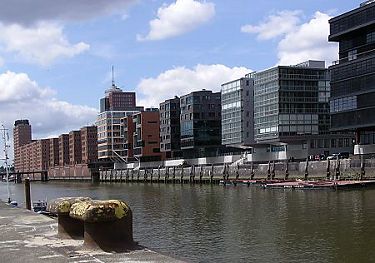 011_14712 Blick vom Kaiserkai zum Sandtorkai; im Hintergrund lks. das Hanseatic Trade Center an der Kehrwiederspitze; im Vordergrund Eisenpoller an der Kaimauer, an der frher die Schiffe im Sandtorhafen fest gemacht haben.