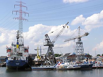 04_22790 - Blick zur Werft am Verkehrshafen, Hafenkrane unter Hochspannungsleitungen.